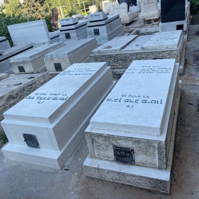 מצבות לבנות עם כיתוב שחור בבית קברות