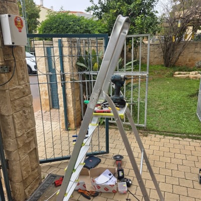 התקנת שער חשמלי עם סולם וכלי עבודה