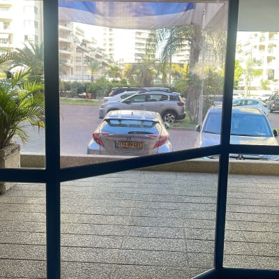 חלון זכוכית עם נוף לרחוב ומכוניות חונות