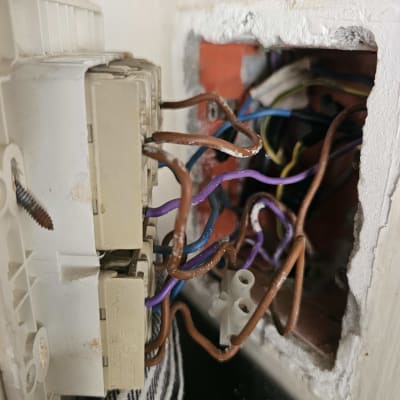 חוטי חשמל מחוברים לשקע בקיר