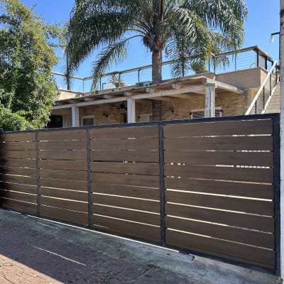 גדר עץ חומה עם מסגרת מתכת שחורה