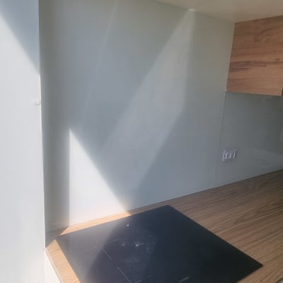 קיר זכוכית במטבח מעל משטח עבודה מעץ