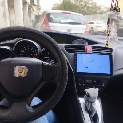 תא נהג של רכב עם הגה, לוח מחוונים ומסך