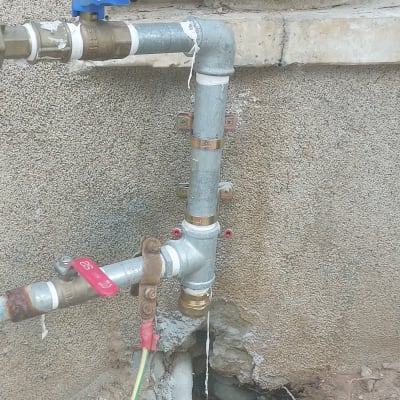 צינורות מתכת עם ברזים על קיר חיצוני