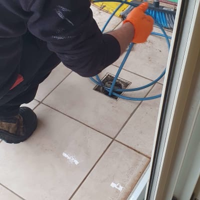 אדם עובד עם כלי אינסטלציה על רצפה