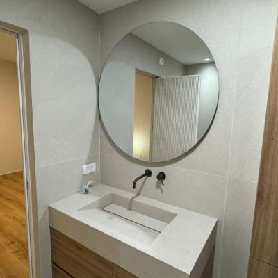 חדר אמבטיה עם כיור ומראה עגולה