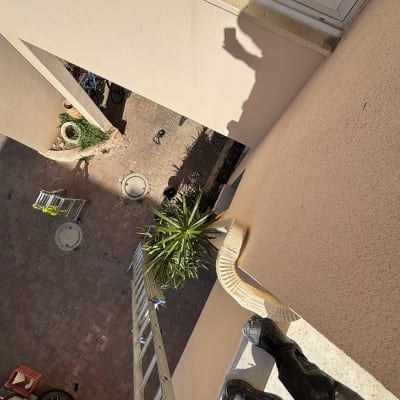 אדם עומד על סולם ליד גג