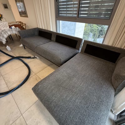 ספות אפורות עם ציוד ניקוי ליד חלון גדול