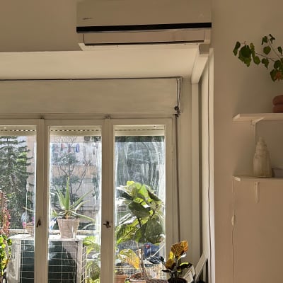 מזגן מותקן על קיר מעל חלון גדול