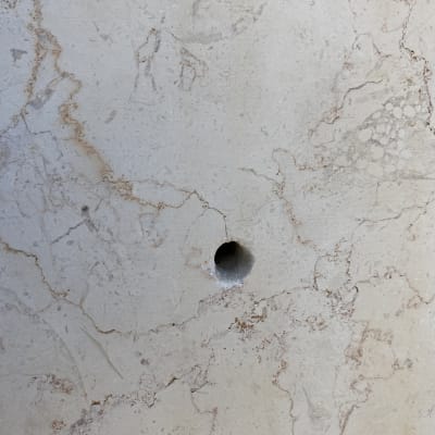 חורים בקיר שיש עם סימני קידוח