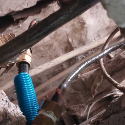 צינורות מים עם חיבורים מתכתיים בקיר חשוף