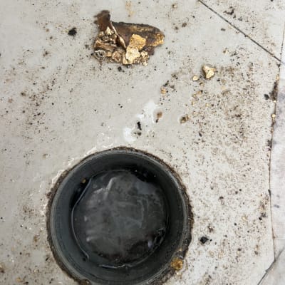 ניקוז סתום עם לכלוך ופסולת על הרצפה