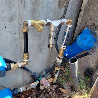 מערכת צנרת עם מסננים וברזים על קיר חיצוני