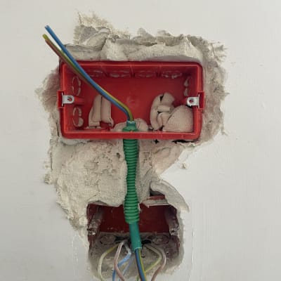 תיבת חשמל פתוחה עם חוטים צבעוניים וקופסה אדומה