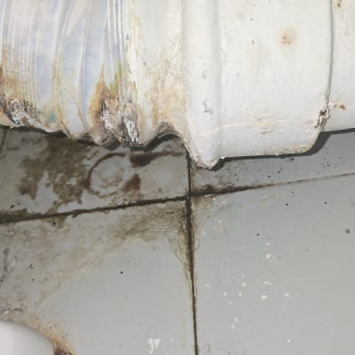 צינור דולף עם סימני חלודה על הרצפה