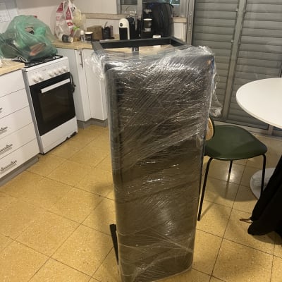 מכשיר עטוף בניילון במטבח עם ארונות לבנים