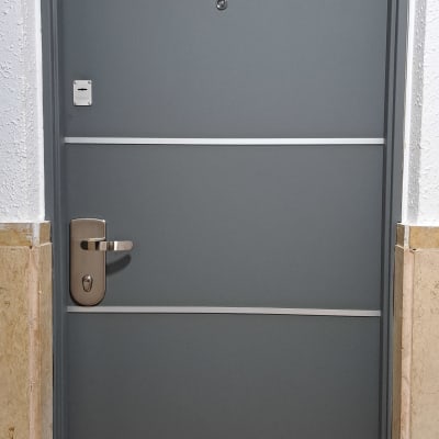 דלת אפורה עם ידית מתכת ופסים אופקיים