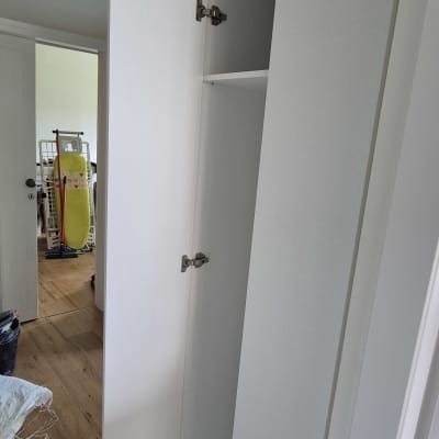 ארון לבן עם דלת פתוחה וצירים מתכתיים