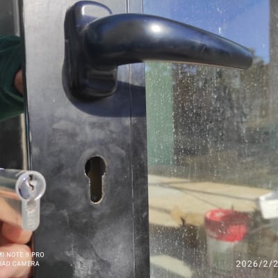 מנעול וצילינדר בדלת זכוכית עם ידית שחורה