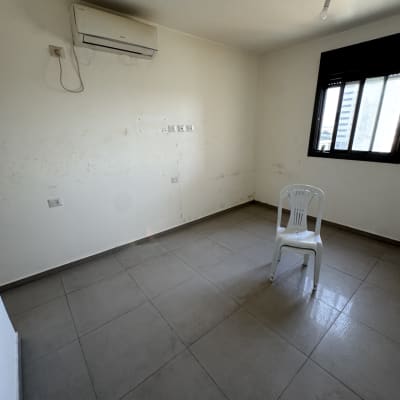 חדר ריק עם כיסא פלסטיק ומזגן על הקיר