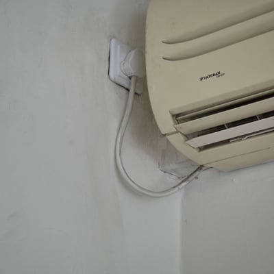 מזגן מחובר לשקע חשמל על קיר