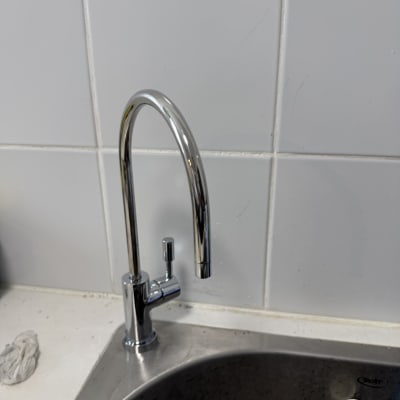 ברז מים מותקן על כיור מטבח עם אריחי קרמיקה