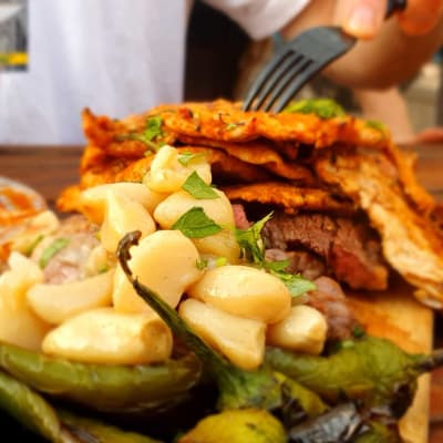 צלחת עם אוכל מגוון, כולל ירקות ובשר, על שולחן עץ