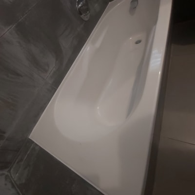 אמבטיה לבנה עם אריחים כהים מסביב