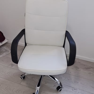 כיסא משרדי לבן עם גלגלים על רצפה מעץ