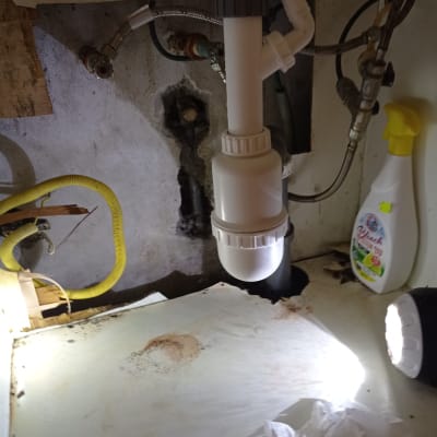 צינור ניקוז לבן מתחת לכיור עם חיבורים