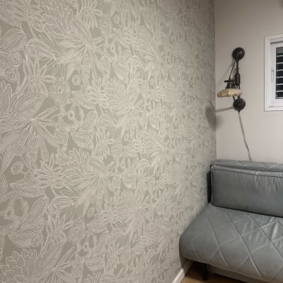 קיר עם טפט פרחוני וספה אפורה