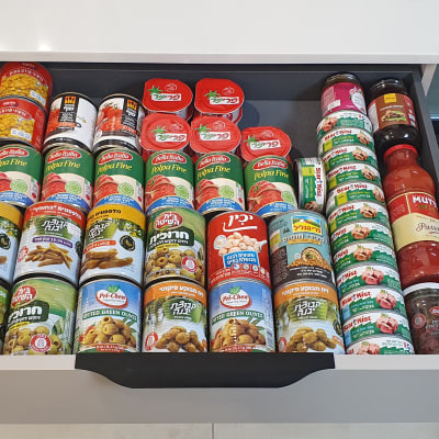 מגירה מסודרת עם קופסאות שימורים וצנצנות מזון