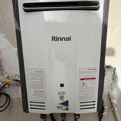 מחמם מים גז מותקן על קיר עם חיבורים וצינורות