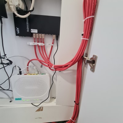 כבלים אדומים מחוברים לנתב ולממיר רשת