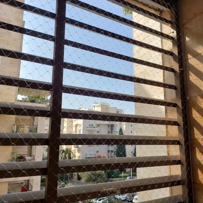 רשת מתכת על חלון למניעת כניסת יונים