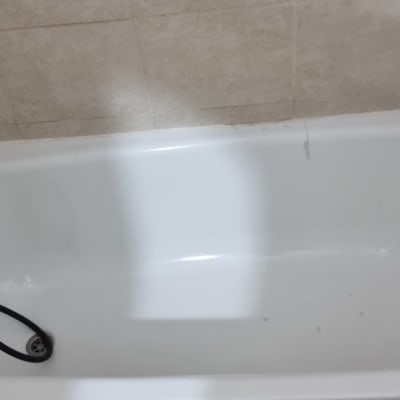 אמבטיה עם ברז שחור וצינור גמיש