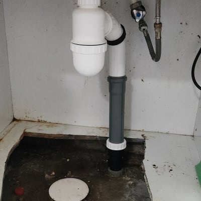 צנרת מתחת לכיור עם חיבורים וצינורות