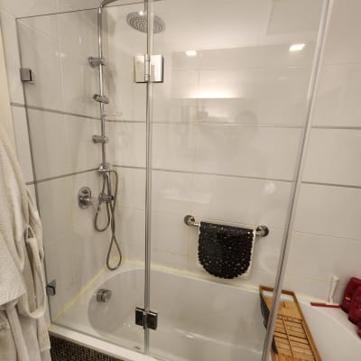 מקלחת עם דלת זכוכית, ראש מקלחת ומדף עץ