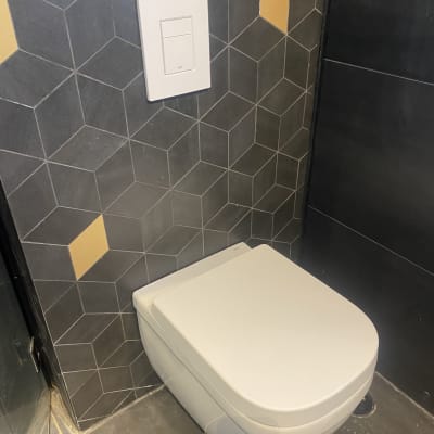 אסלה תלויה עם לחצן הדחה על קיר אריחים