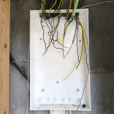 חוטי חשמל צבעוניים בתוך תיבת חיבורים פתוחה