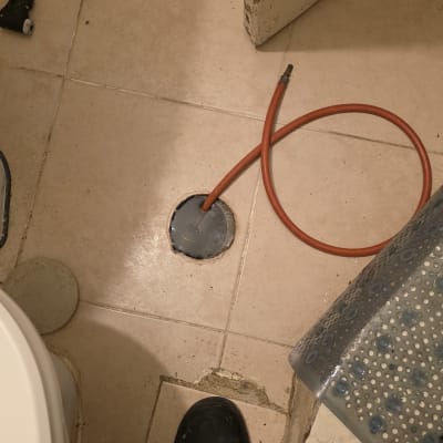 צינור כתום מחובר לרצפה בחדר אמבטיה