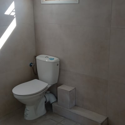 שירותים עם חלון פתוח וקירות מחופים באריחים