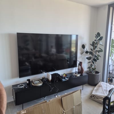 טלוויזיה תלויה על קיר עם ציוד אלקטרוני