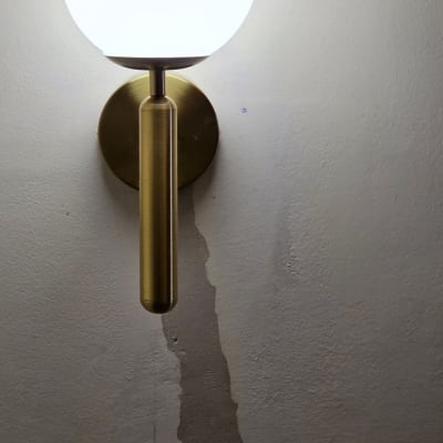 מנורת קיר עגולה ושקע חשמל על קיר