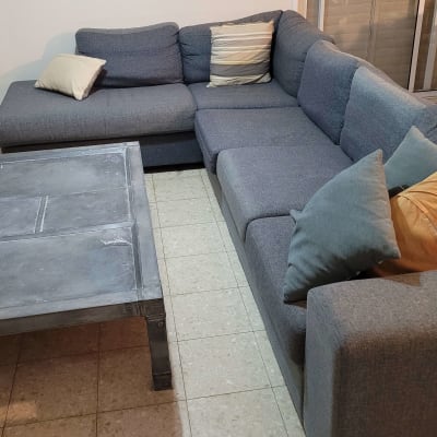 ספה גדולה עם כריות ושולחן מתכת בחדר מגורים
