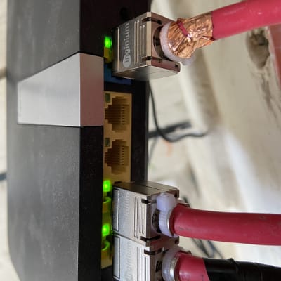 כבלים אדומים מחוברים לנתב עם נוריות ירוקות דולקות