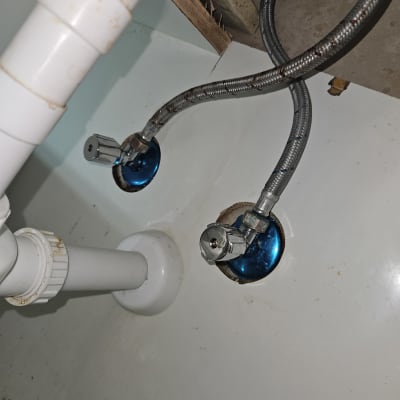 צינורות מתכת וברזים מתחת לכיור