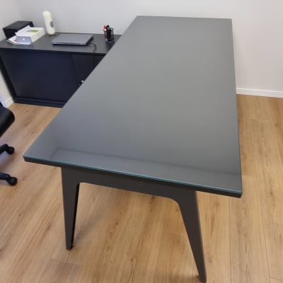 שולחן זכוכית עם רגליים כהות על רצפת עץ