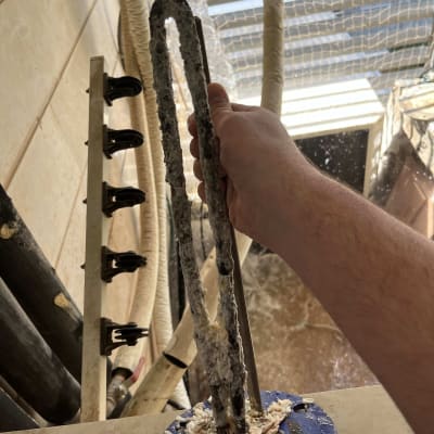 יד מחזיקה גוף חימום עם אבנית על רקע דוד שמש