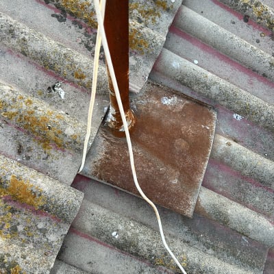 תמונה של גג עם חוטים ומוט מתכת חלוד